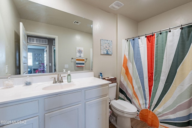 full bath featuring toilet, vanity, and visible vents