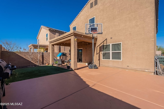 back of house with a patio area, fence, and stucco siding