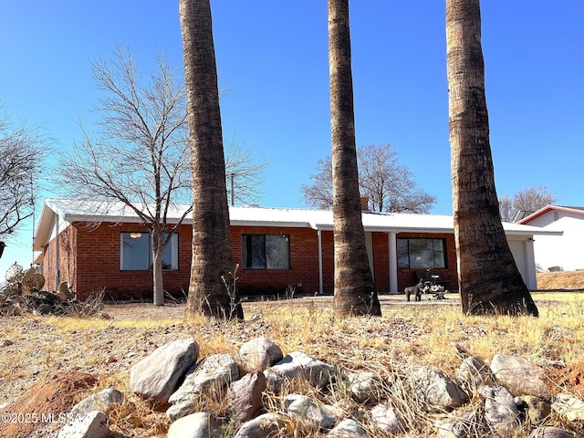 exterior space with brick siding and metal roof