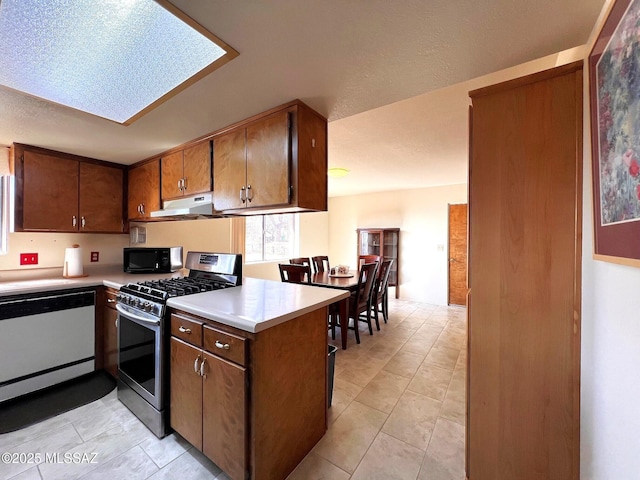 kitchen with black microwave, dishwashing machine, under cabinet range hood, light countertops, and stainless steel gas stove