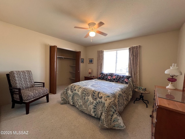 carpeted bedroom with a ceiling fan, a closet, and a textured ceiling