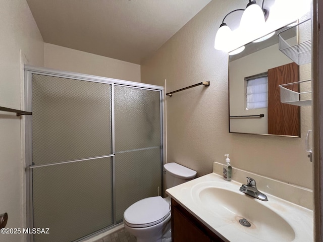 full bath with vanity, a shower stall, and toilet