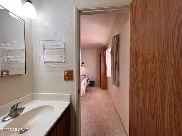 bathroom featuring a textured wall and vanity