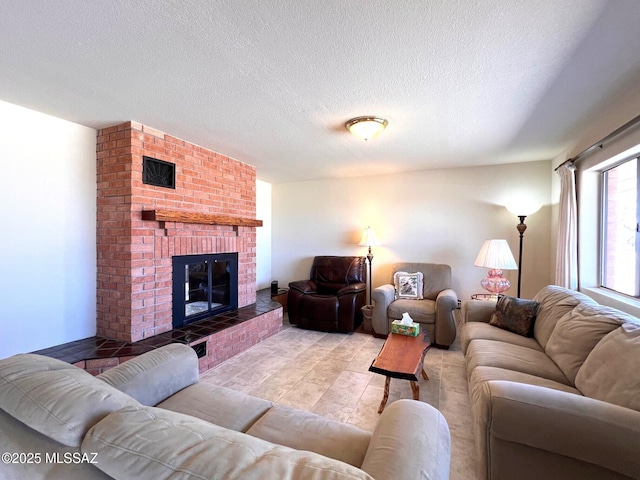 living room with a textured ceiling, a fireplace, and visible vents