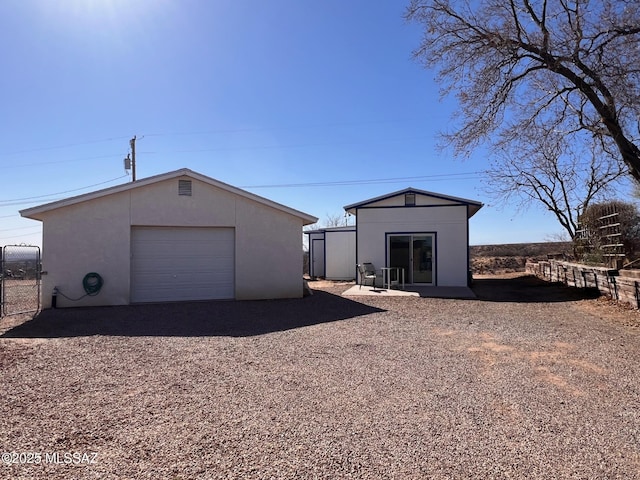 view of outbuilding featuring an outbuilding, driveway, and fence