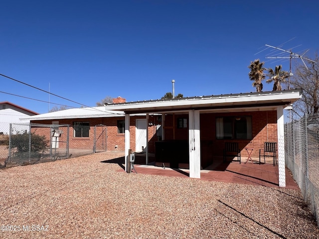 back of property featuring a patio, brick siding, and fence