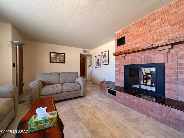 living area with visible vents, a fireplace, and a textured ceiling