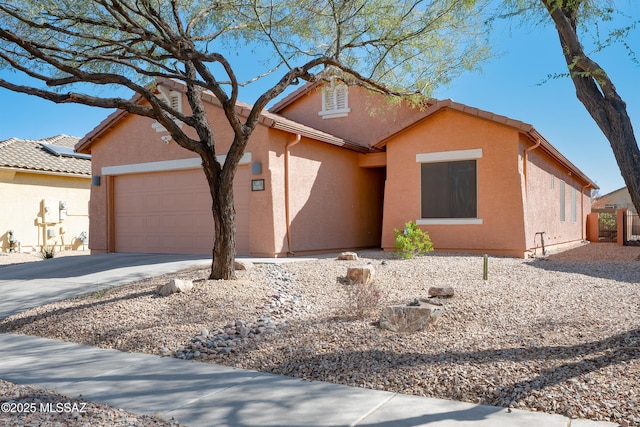 ranch-style home featuring driveway, an attached garage, a tiled roof, and stucco siding