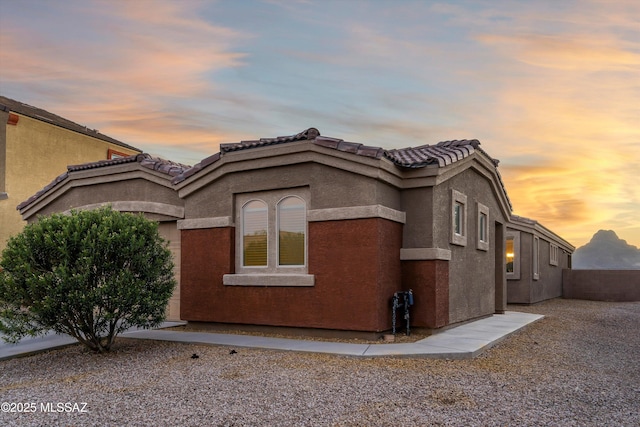 view of home's exterior with a tiled roof and stucco siding