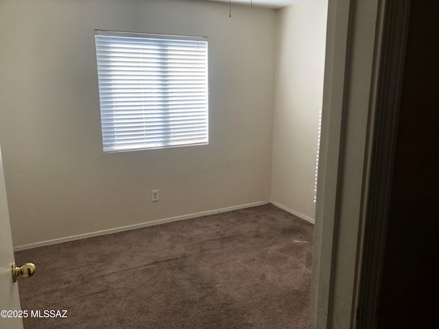 carpeted spare room featuring baseboards