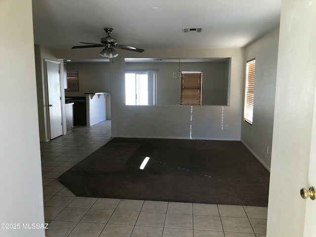 spare room with ceiling fan, visible vents, baseboards, and tile patterned floors