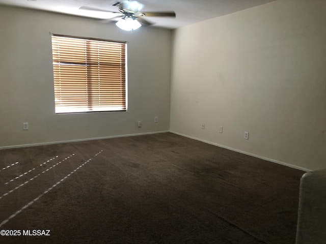 carpeted spare room with a ceiling fan and baseboards