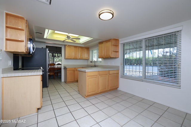 kitchen with a raised ceiling, open shelves, light countertops, and light brown cabinets