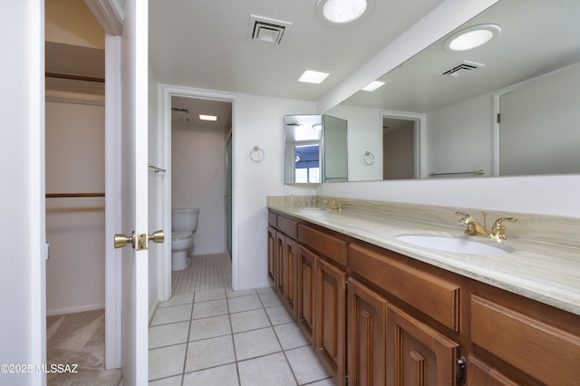 bathroom featuring toilet, a sink, and visible vents