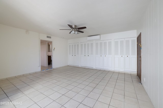 unfurnished bedroom featuring a ceiling fan, a wall mounted air conditioner, visible vents, and two closets