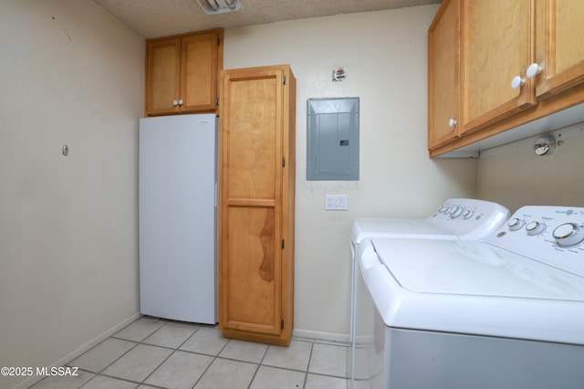 laundry room featuring cabinet space, electric panel, baseboards, washer and dryer, and light tile patterned flooring