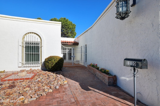 exterior space featuring a tiled roof and stucco siding