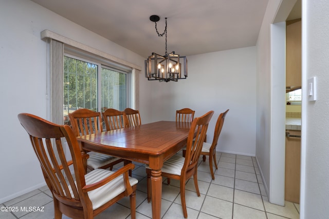 dining area with light tile patterned flooring, an inviting chandelier, and baseboards