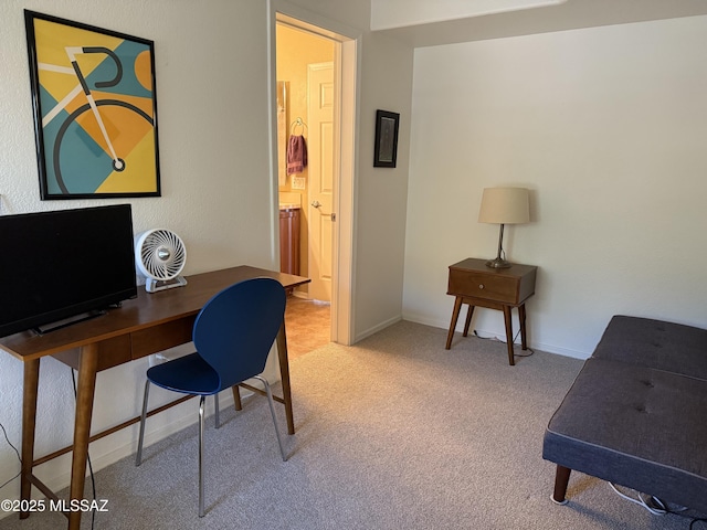 office area featuring light carpet and baseboards