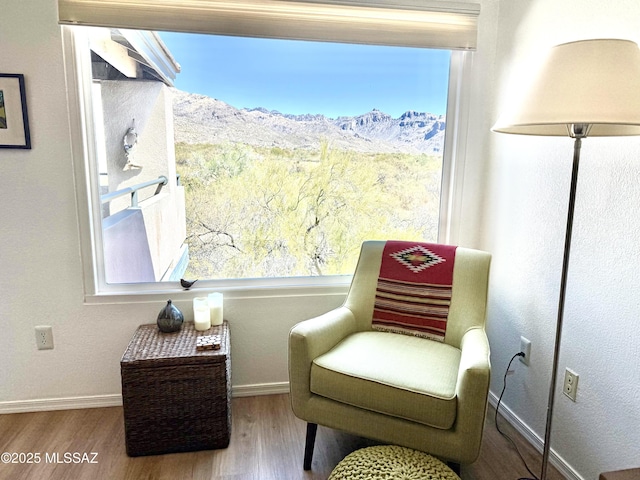 living area with baseboards and wood finished floors