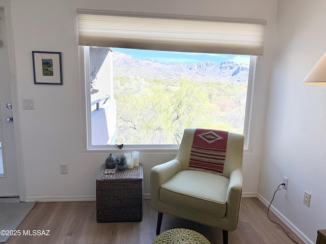 sitting room with baseboards and wood finished floors