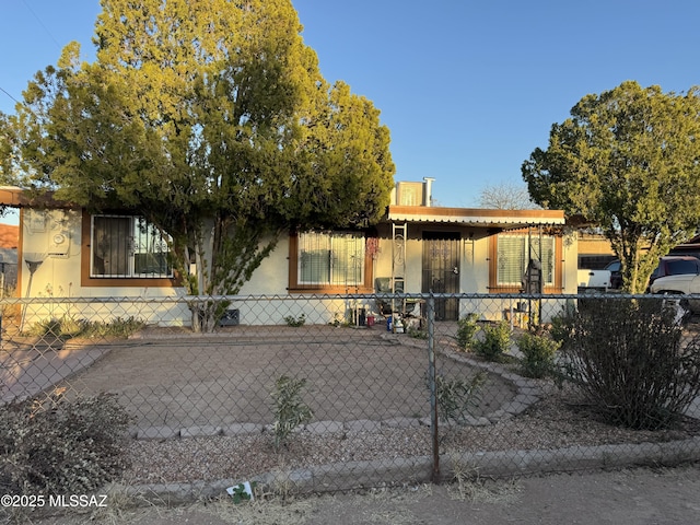 view of front of property featuring a fenced front yard and stucco siding