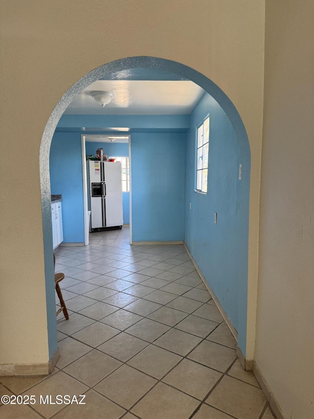 5017 S 11th Ave, Tucson, AZ 85706 - unfurnished room with arched walkways, light tile patterned flooring, and baseboards