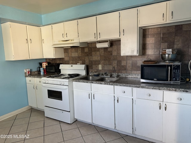 5017 S 11th Ave, Tucson, AZ 85706 - kitchen featuring white gas stove, under cabinet range hood, dark countertops, and decorative backsplash