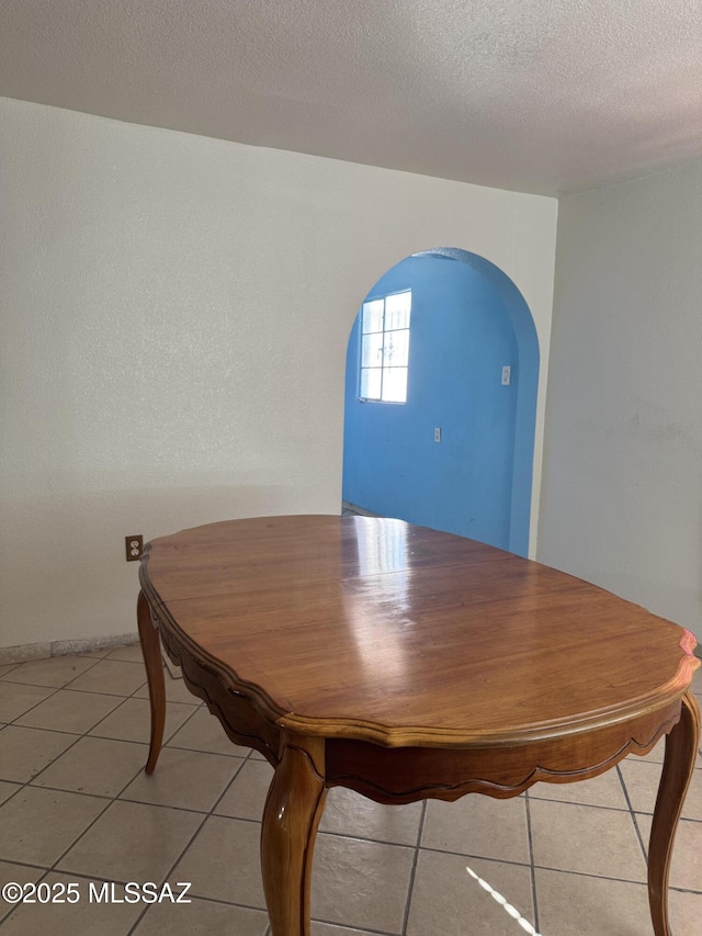 5017 S 11th Ave, Tucson, AZ 85706 - dining space featuring arched walkways, light tile patterned floors, and a textured ceiling