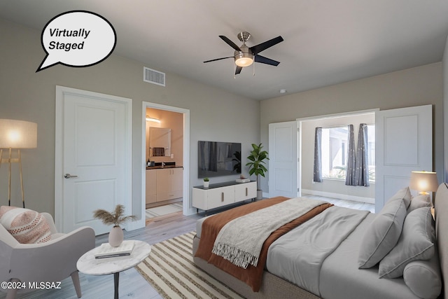 bedroom featuring connected bathroom, visible vents, and light wood-style flooring