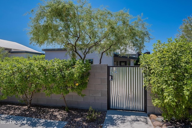 view of gate with a fenced front yard