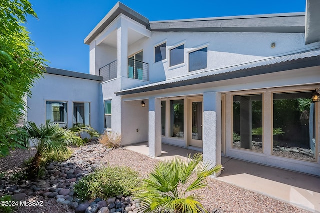 back of house featuring stucco siding and a patio