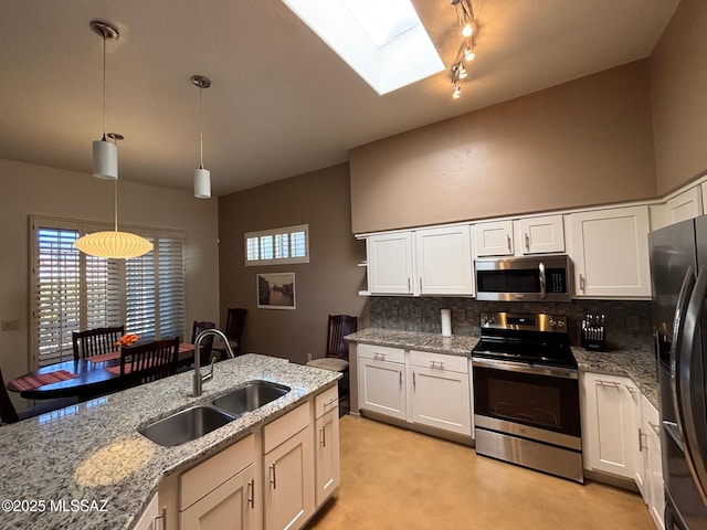 kitchen with a sink, appliances with stainless steel finishes, white cabinets, and tasteful backsplash