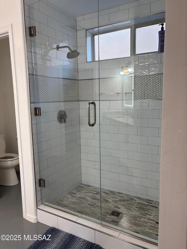 bathroom featuring a stall shower and toilet