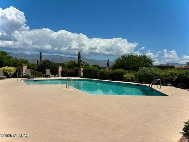 community pool with a patio and a mountain view