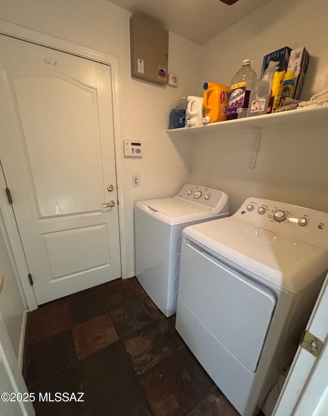 washroom with laundry area, washer and clothes dryer, and stone finish flooring