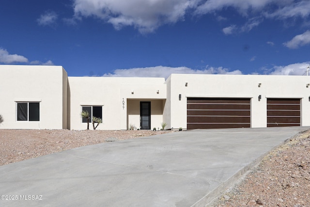 view of front of house featuring stucco siding, a garage, and concrete driveway