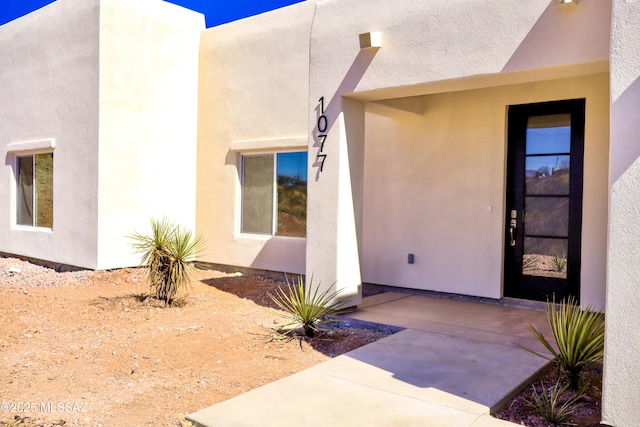 property entrance with stucco siding