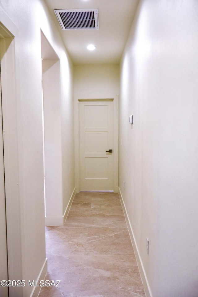 hallway featuring visible vents and baseboards