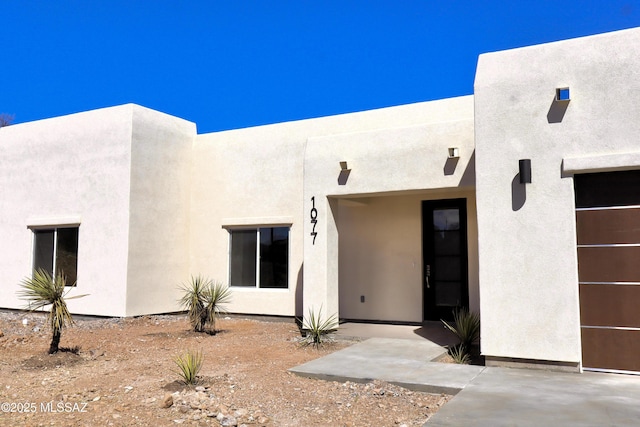 entrance to property featuring stucco siding