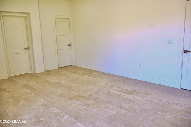 spare room with baseboards