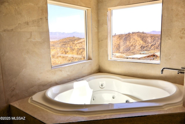 full bathroom with a jetted tub and a mountain view