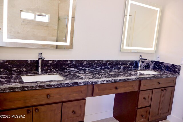 bathroom featuring double vanity, a sink, and walk in shower