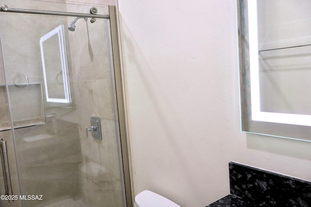 bathroom with toilet and a stall shower