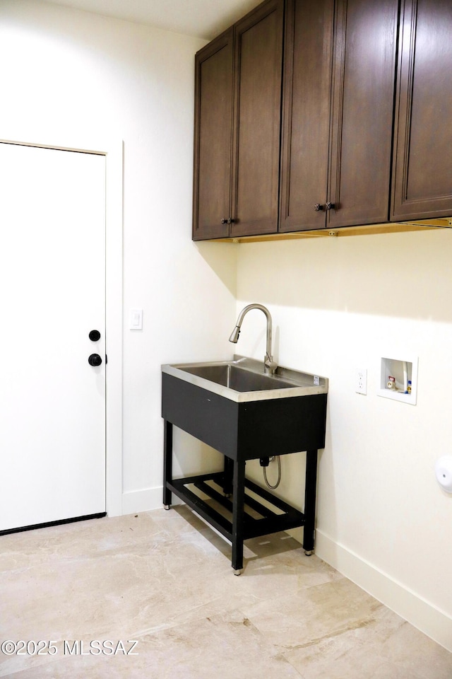 laundry area with washer hookup, cabinet space, baseboards, and a sink