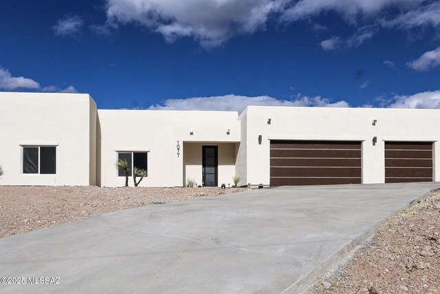 view of front of house featuring driveway, stucco siding, and an attached garage