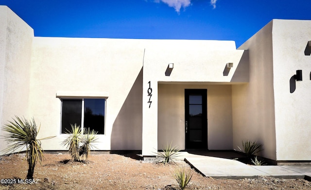 view of exterior entry featuring stucco siding