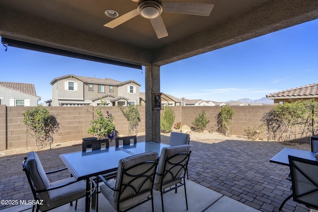 view of patio with a ceiling fan, a residential view, outdoor dining area, and a fenced backyard