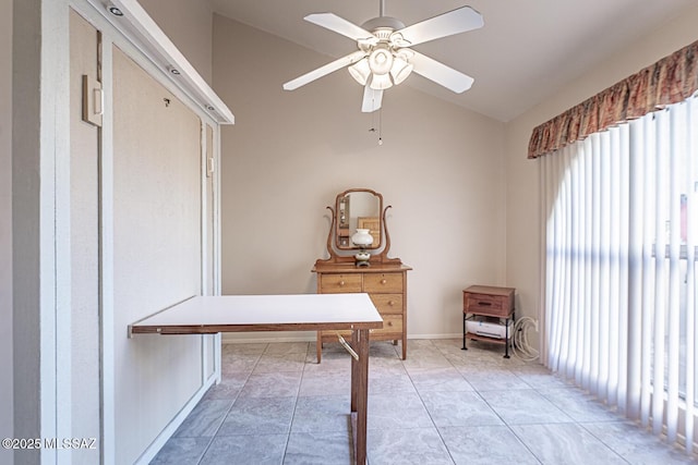 unfurnished office with vaulted ceiling, a ceiling fan, and light tile patterned flooring