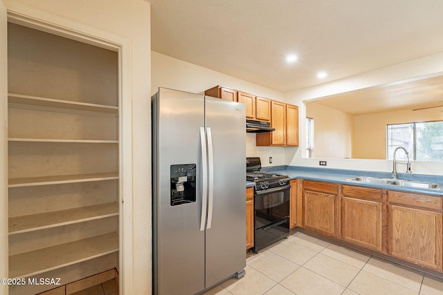 kitchen with light tile patterned floors, black range with gas stovetop, a sink, under cabinet range hood, and stainless steel fridge with ice dispenser